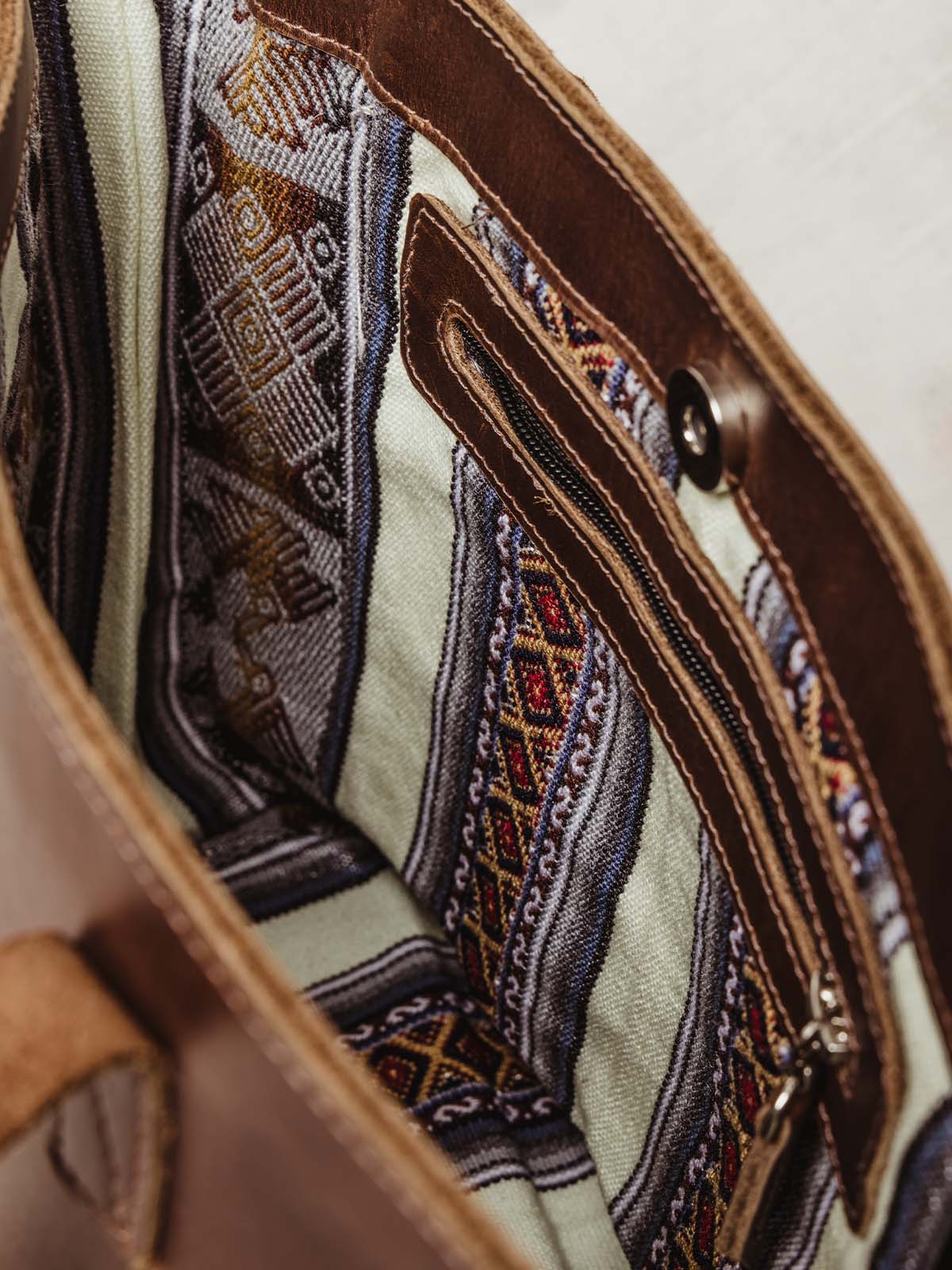 Inside of braided shoulder bag with tribal pattern and leather zipper 