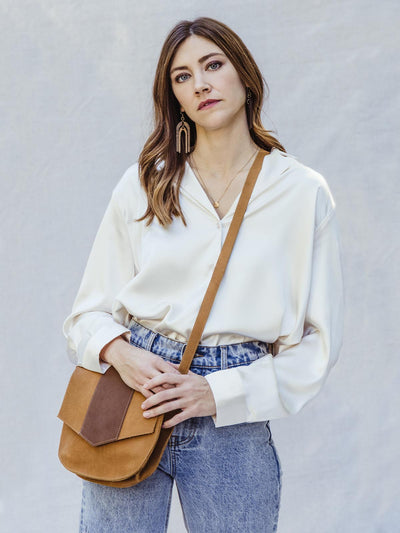 female model in silk top and denim jeans with crossbody satchel 