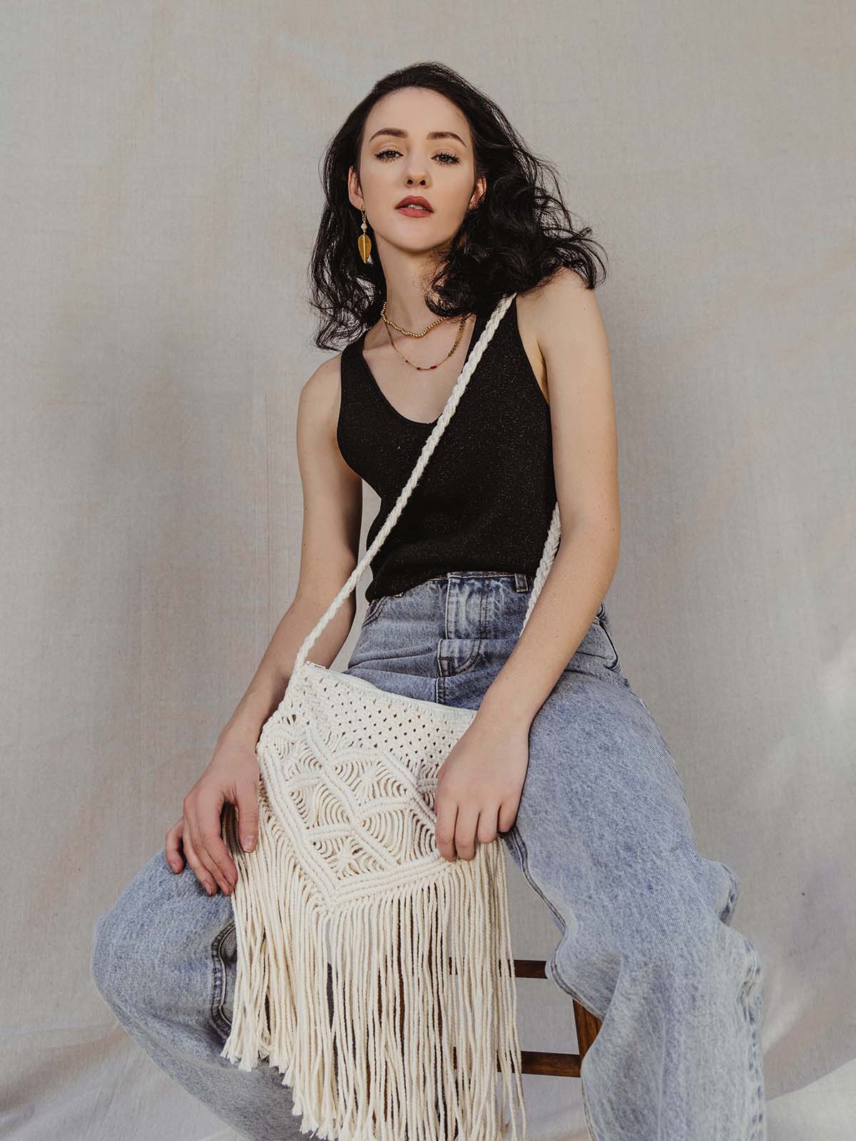 Female model wearing Macrame purse in black tank and jeans crossbody.