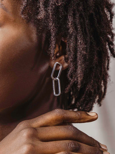 Close up of model's ear with silver earrings on