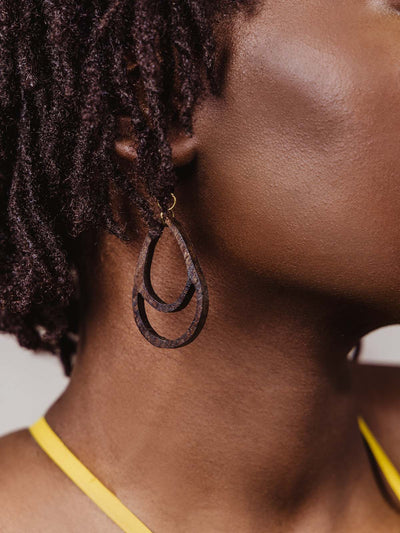 Model wearing dark brown wooden teardrop earrings