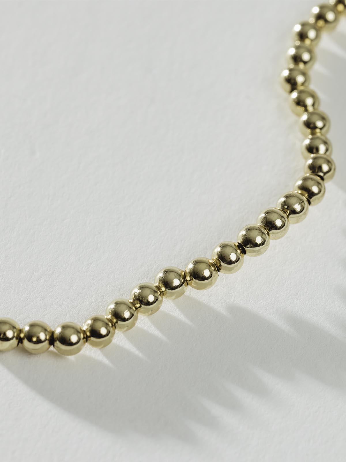 Close up of Gold Beaded Choker on white background