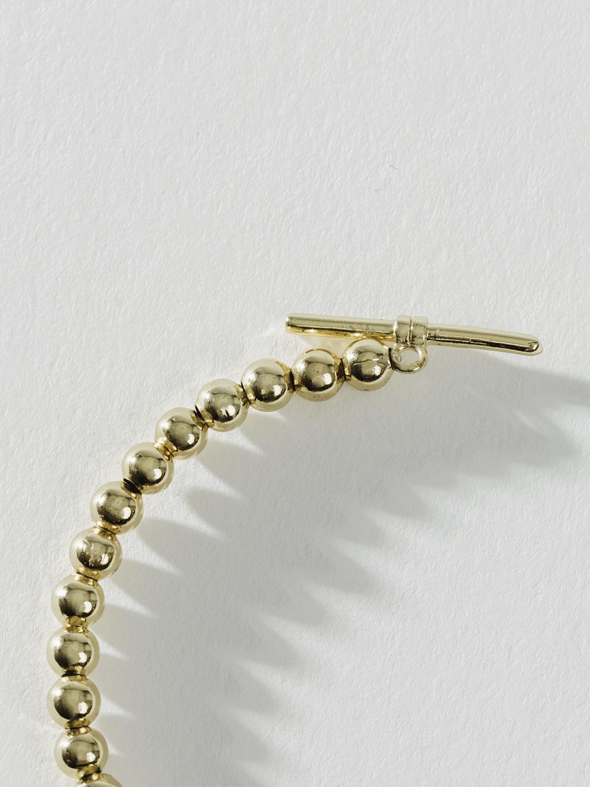 Close up of Gold Beaded Choker on white background