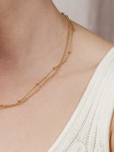 Close up of neck with gold double choker necklace