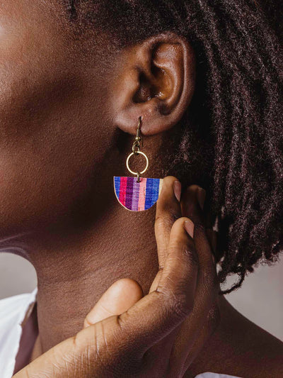 blue, pink, maroon, purple, blue and yellow half circle earrings with gold metal on model wearing white shirt. 