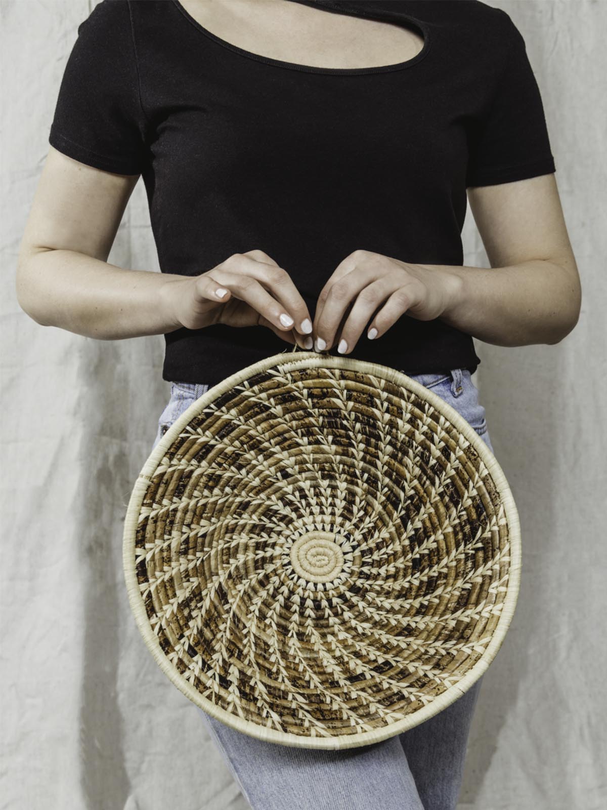 Model holding large brown and tan basket.