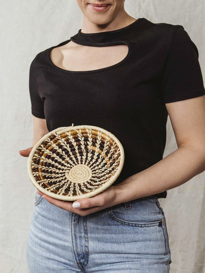 Model holding small brown and tan basket.