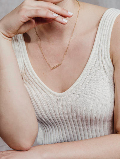 Model wearing golden chain with five bead pendant