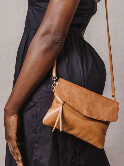 Model wearing the brown leather crossbody clutch