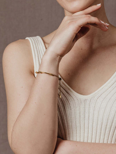 model wearing gold knot bracelet with chain