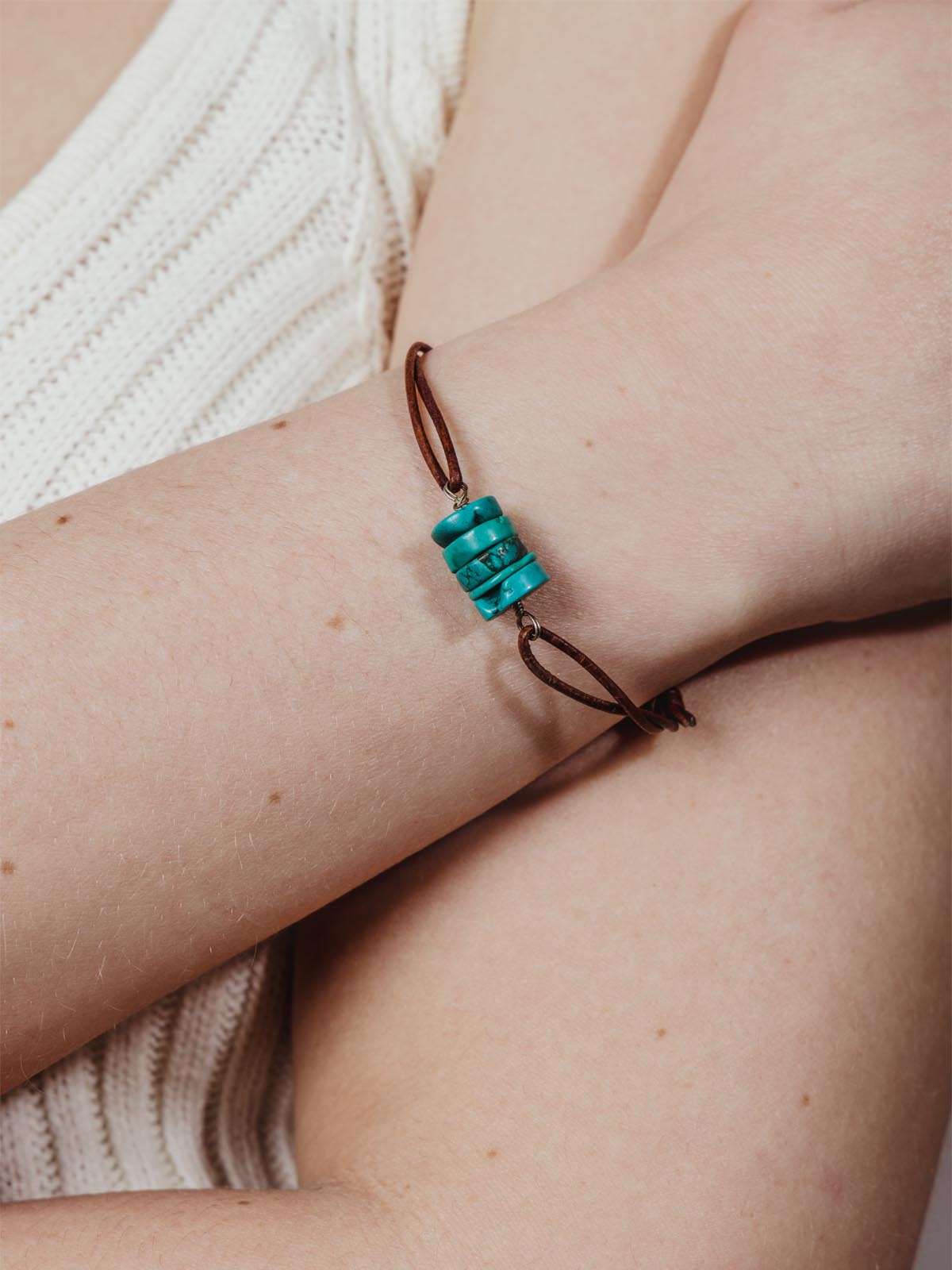 Model wearing leather adjustable bracelet with turquoise beads.