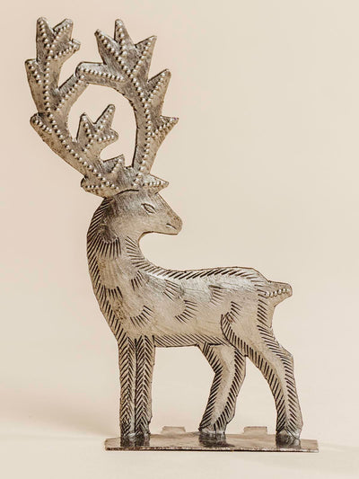 Silver reindeer standing on a beige background. 