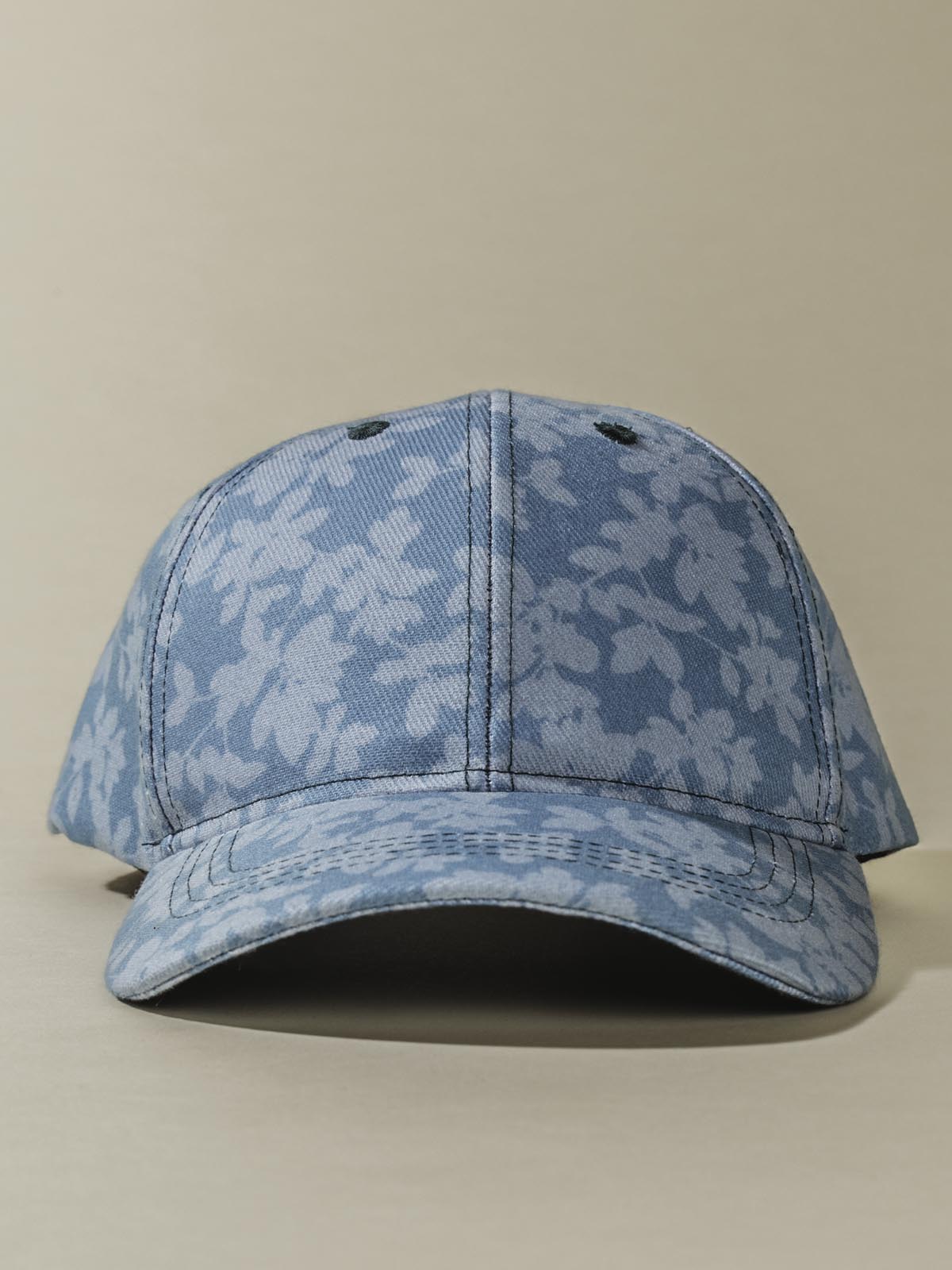 Front of teal Hat with light floral design on tan background.