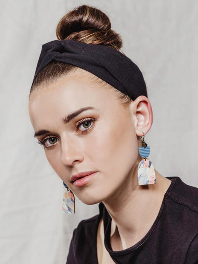 Model wearing black headband with twisted knot on the top.