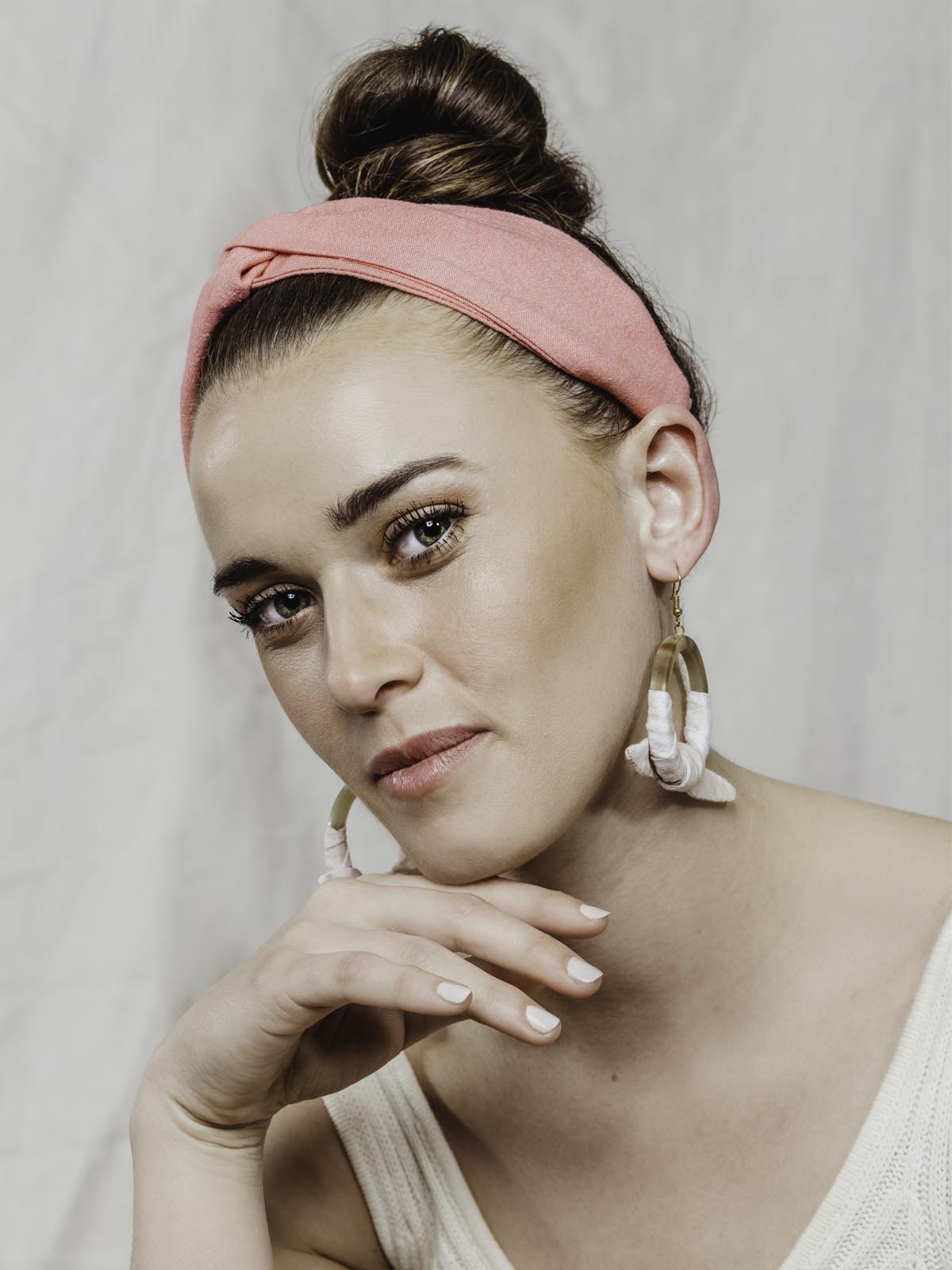 Model wearing coral pink cloth headband.