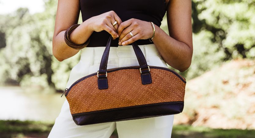 Two women standing in front of a black car with two leather tote bags