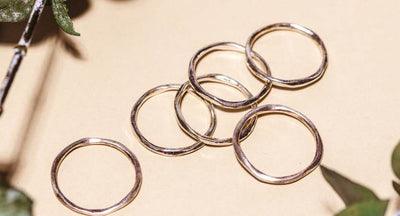 Women in thinking post with gold and white necklace, jewelry and bracelet.