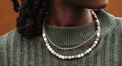 Women wearing blue bone bead necklace and black tank top