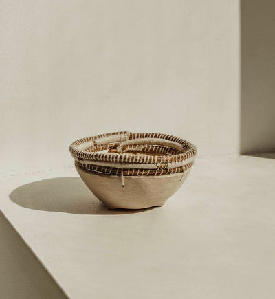 Tan clay bowl with shadows in the background