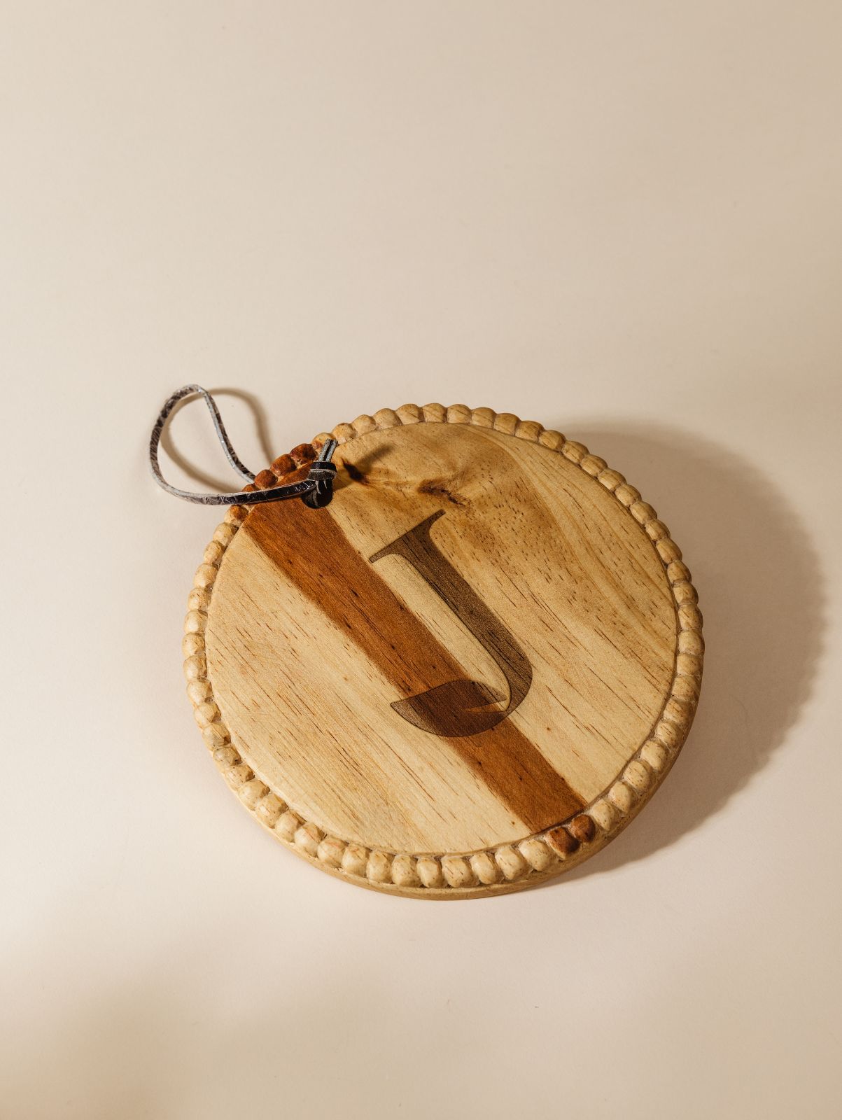 Circular charcuterie board on cream background with large logo customized on board. 