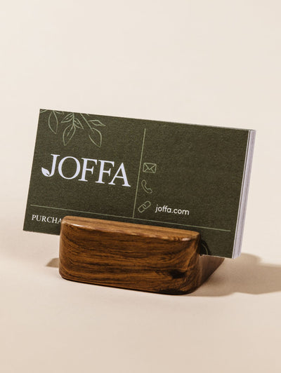 Cell phone stand holding business cards on cream background. 