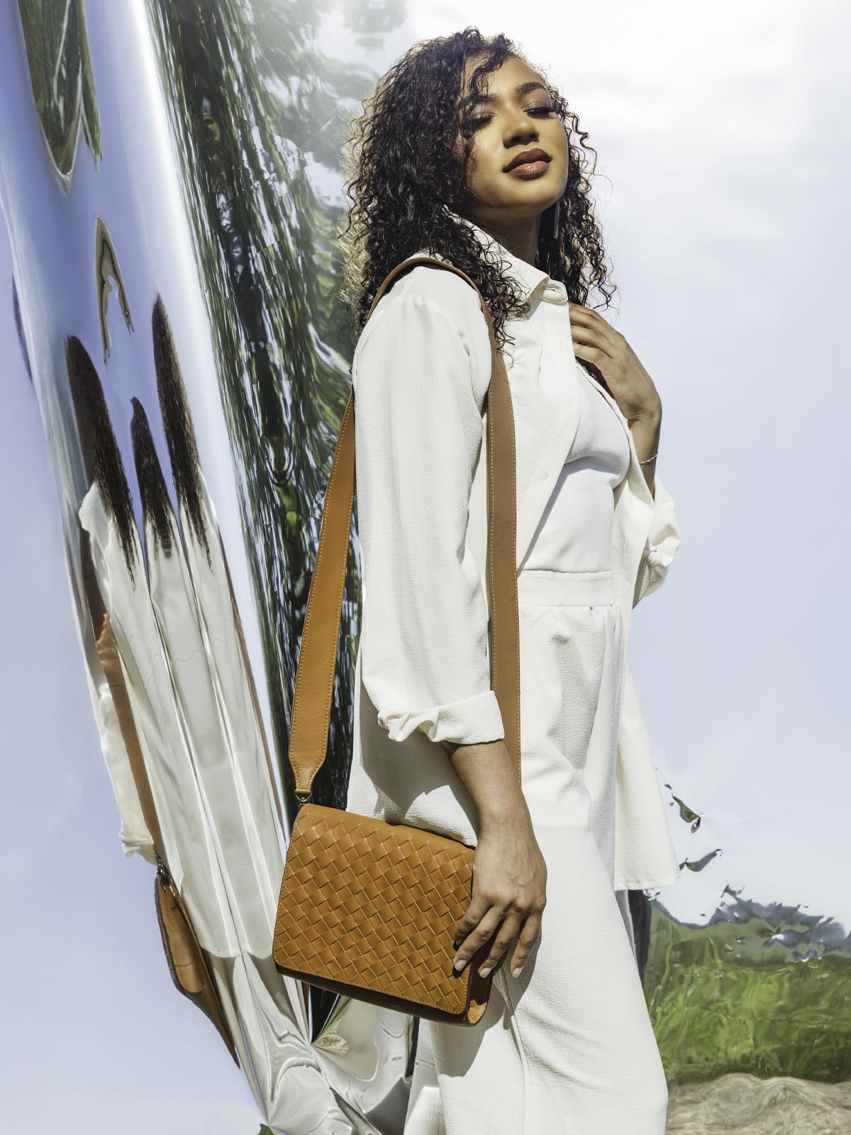 Model with handmade braided leather hand bag over the shoulder. 