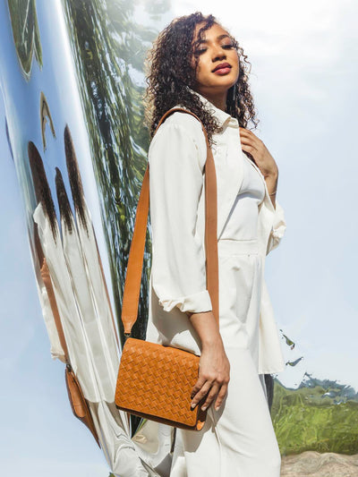 Model with handmade braided leather hand bag over the shoulder. 