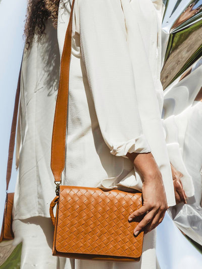 Model with handmade braided leather hand bag over the shoulder. 