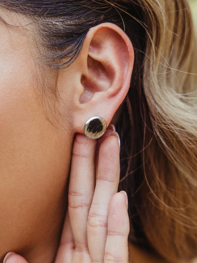 Three stud earrings on beige background