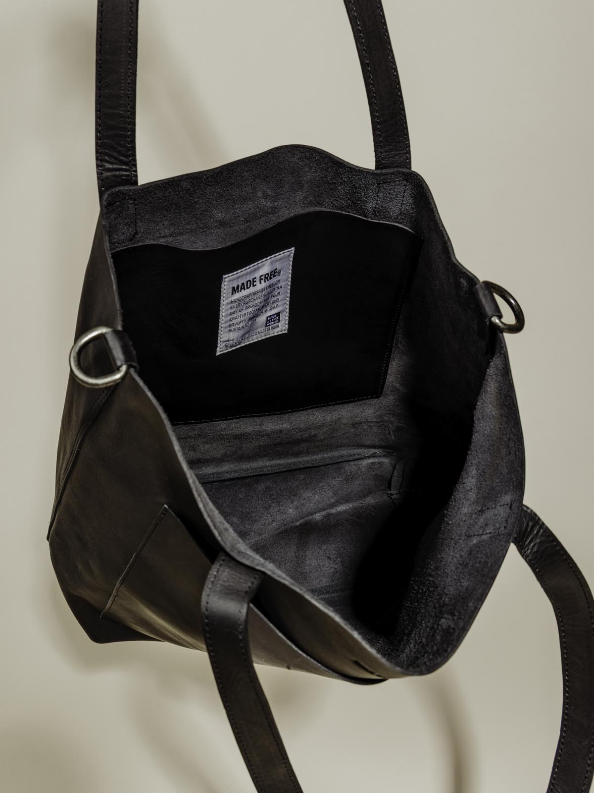 Interior photo of Made Free black leather bag on a neutral background.