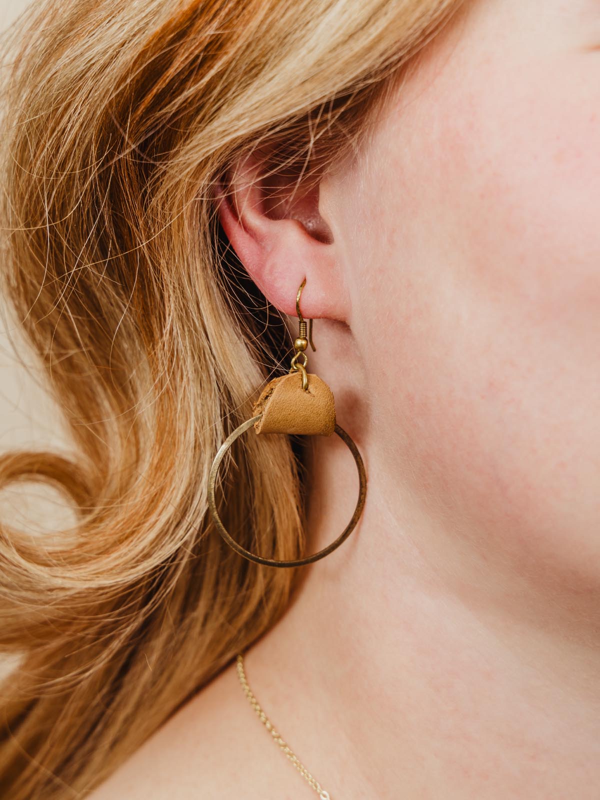 Circle of hope earrings being worn by a woman. 