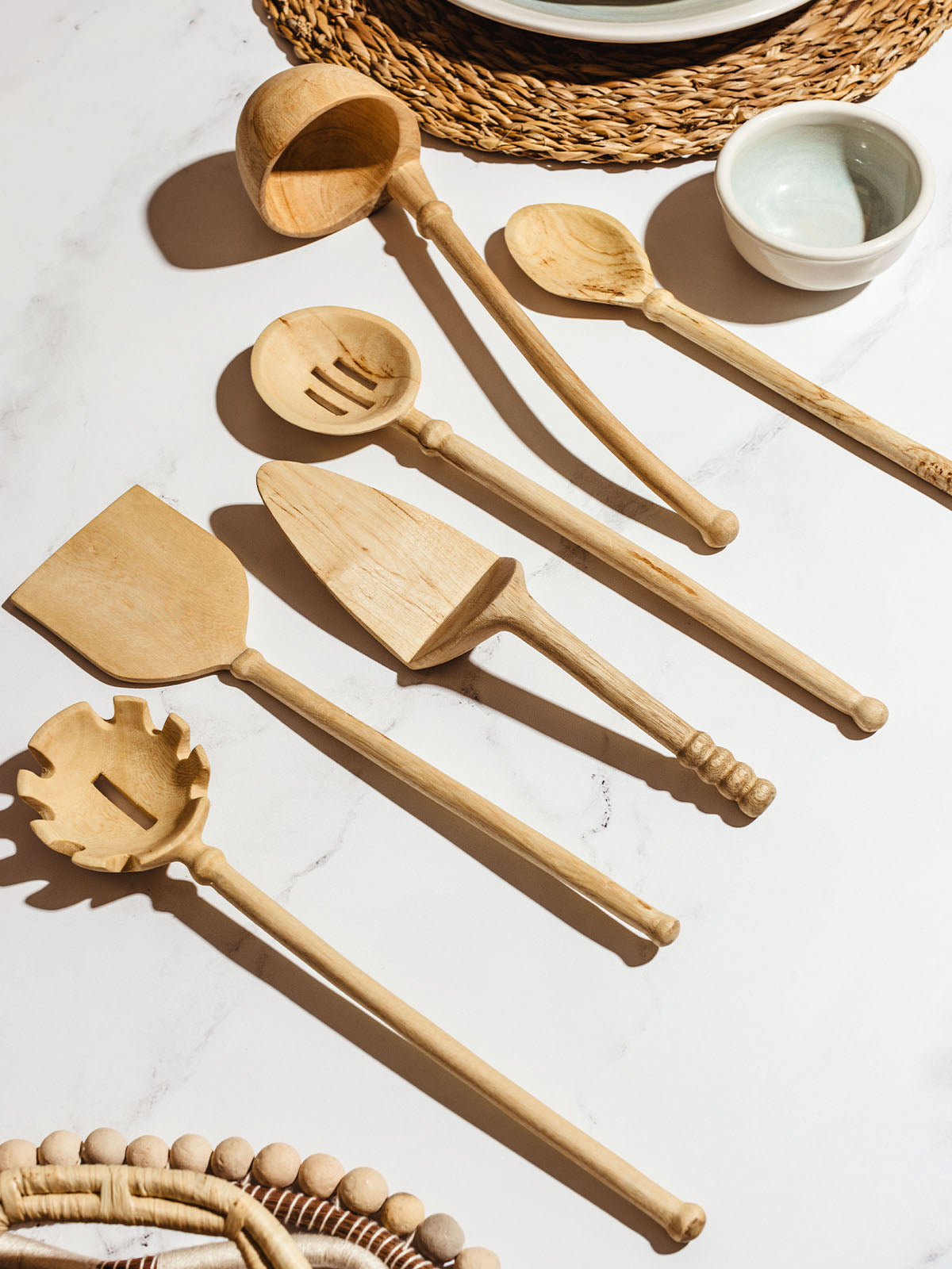 Wooden kitchen utensils on white granite counter top.