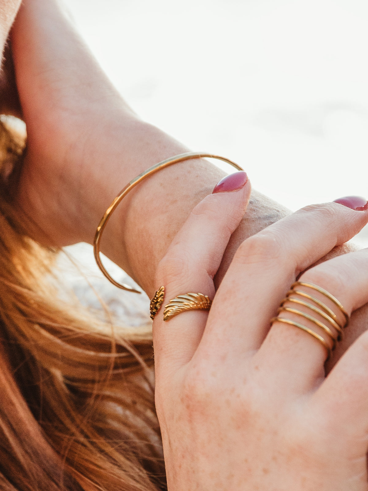 Close up image of female model wearing forai’s brass bangle band