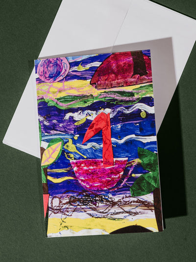 Greeting card displaying a bold, artistic scene of a red swan on a blue and purple river with green plants and abstract elements, resting on a white envelope.