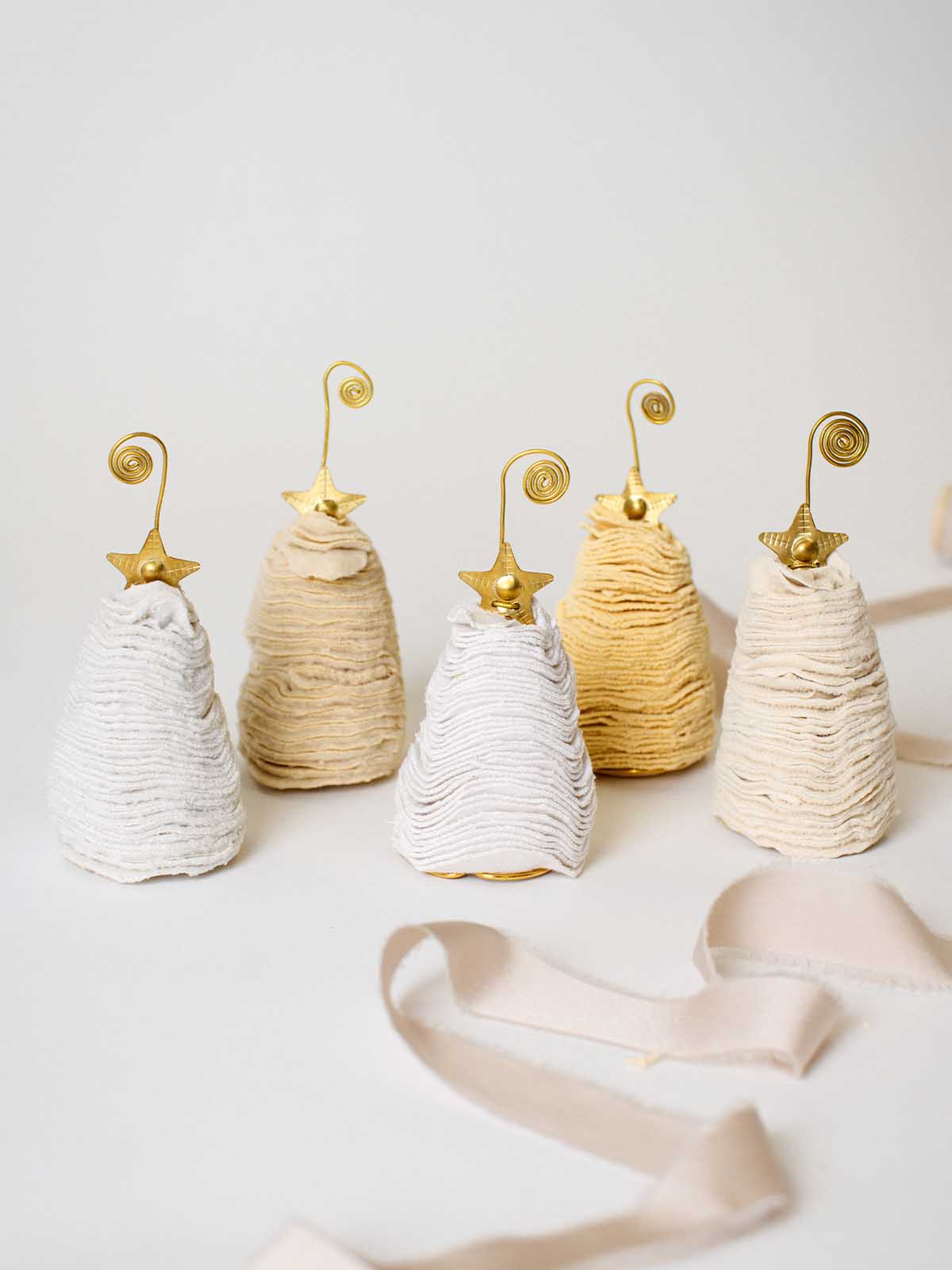 Neutral sweater Christmas tree ornaments with gold star toppers and spiral hooks, handcrafted for cozy holiday décor.