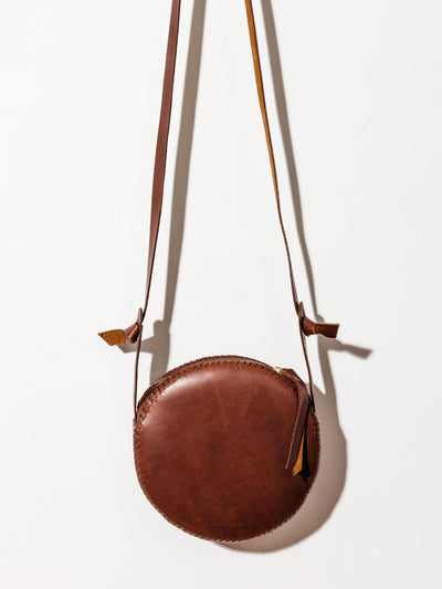 Leather canteen circle purse on white background.