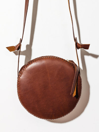 Leather canteen circle purse on white background.