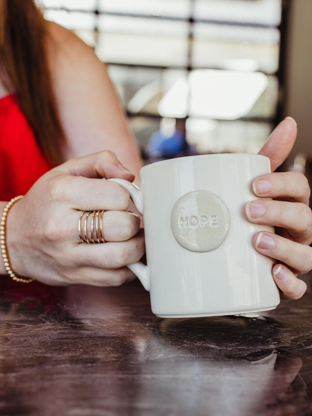 female model hands holding white hope mug.