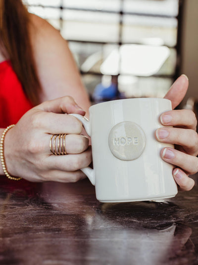 female model hands holding white hope mug.