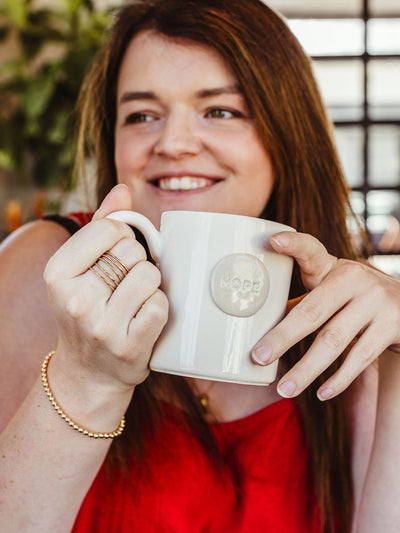 Female model holding hope mug.