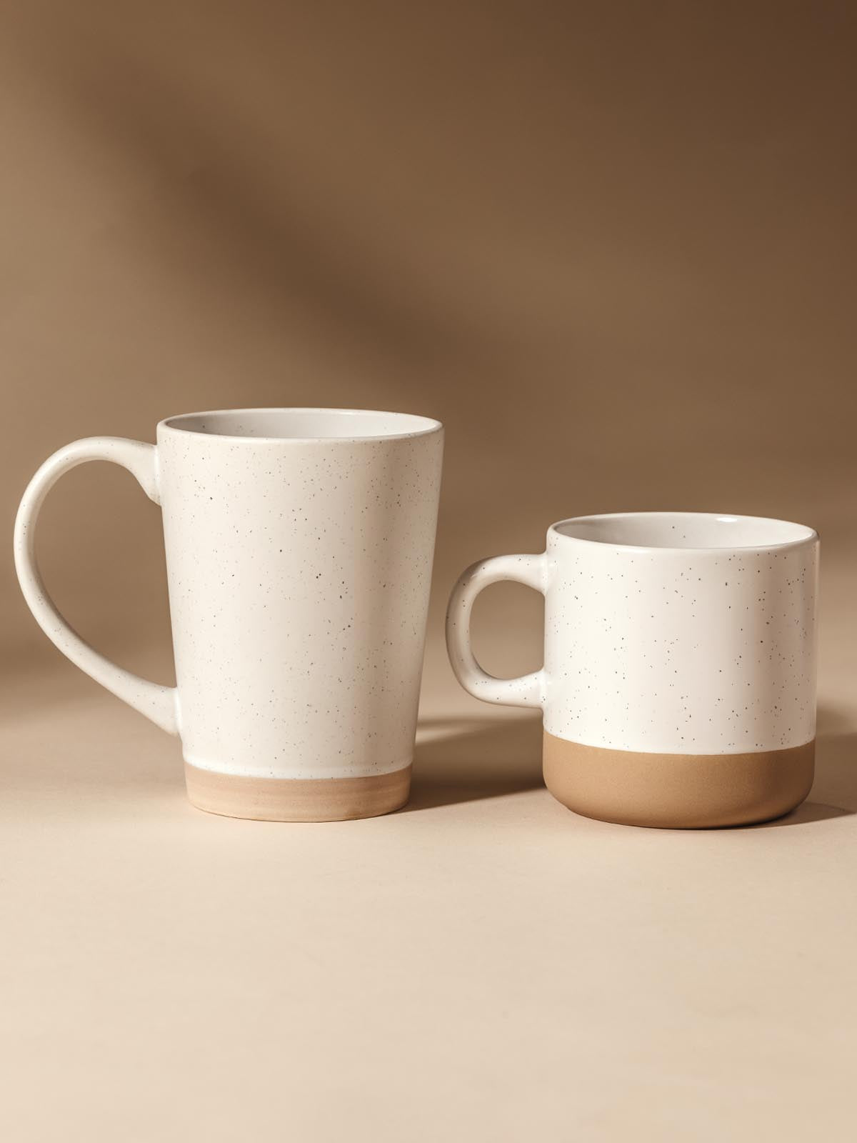 16 oz and 10 oz ceramic mugs on cream background.