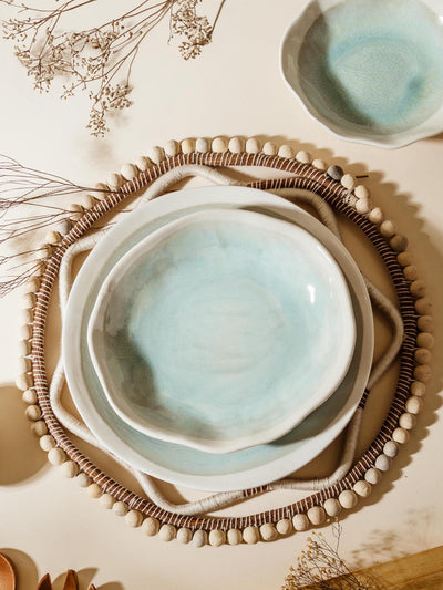Artisan Pottery Dinnerware Set on cream background with dried flowers