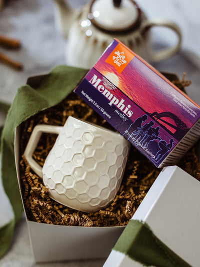 Memphis gift bundle featuring artisan honeycomb textured ceramic mug and Memphis Medley tea sampler, packaged in white gift box with crinkle paper and green ribbon, perfect local Memphis gift set.