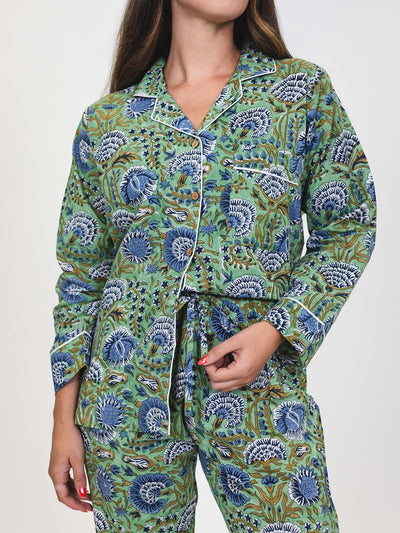 Close-up of the green and blue floral pajama set, showing button-down top, pocket with white piping, and drawstring waist pants.