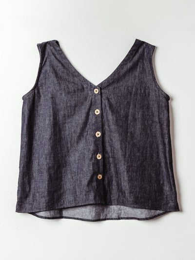 The back of a dark denim tank top shown flat against a light background. This view highlights the deep V-back and a row of five wooden buttons down the center, adding a charming, rustic detail to the classic style.