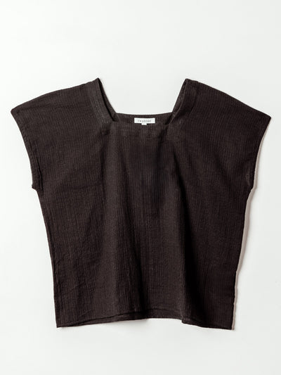A black textured short-sleeve top is laid flat against a light background. The top features a wide square neckline, relaxed boxy fit, and soft crinkled fabric with subtle vertical striping. The simple silhouette and lightweight material create an easy, breathable look.