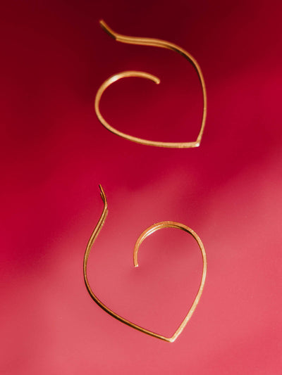 Piple gold earrings on a red background.