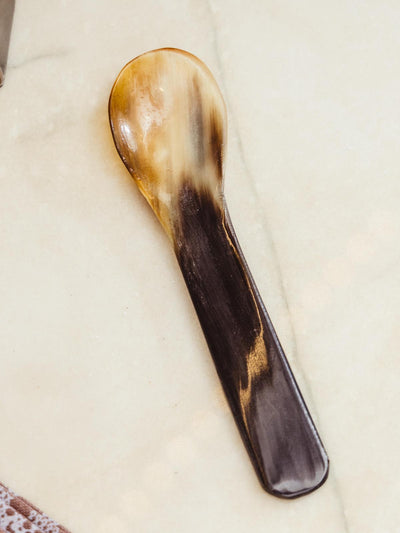Short horn spoon on white counter top.