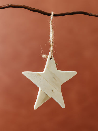 Handcrafted bone star ornament with jute string, minimalist eco-friendly Christmas tree decoration made from sustainable natural materials.