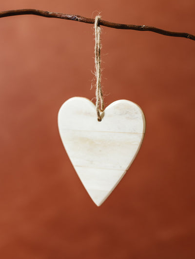 Handmade bone heart ornament on rustic twine, sustainable Christmas decoration for eco-conscious and fair trade holiday styling.